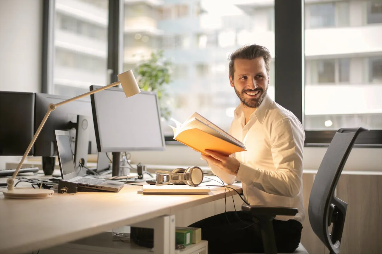 Klant aan zijn bureau met een boek in de hand